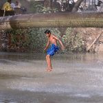 A youngster dives into a canal at Hala Naka to escape the summer heat