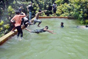 Youngsters enjoy bathing under a running tube-well to get relief from the scorching heat at Khesana Mori village.