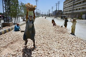 Labourers are busy in road expansion work during an ongoing development project being carried out by the district government at Autobahn Road