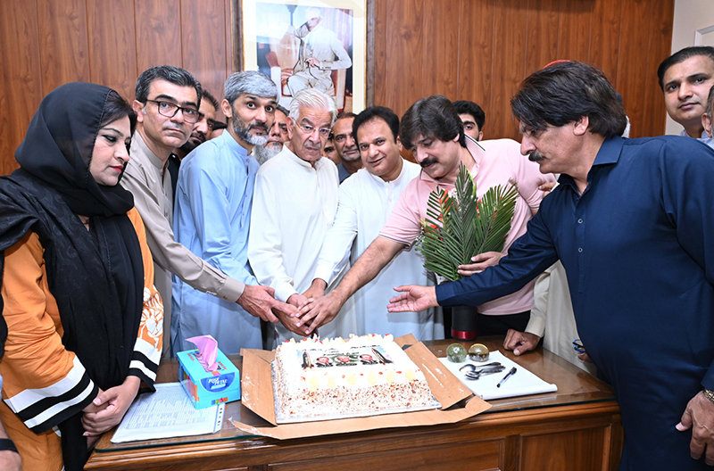 Defense Minister Khawaja Muhammad Asif cutting the Takbeer Day cake with his workers at his liaison office in Cantt