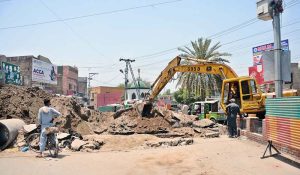 Workers dig a trench with heavy machinery to lay a sewerage pipeline during ongoing development work at Daulat Gate.