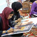 Art students paint portraits during a painting competition organized by the Information and Culture Department Punjab at the Multan Arts Council