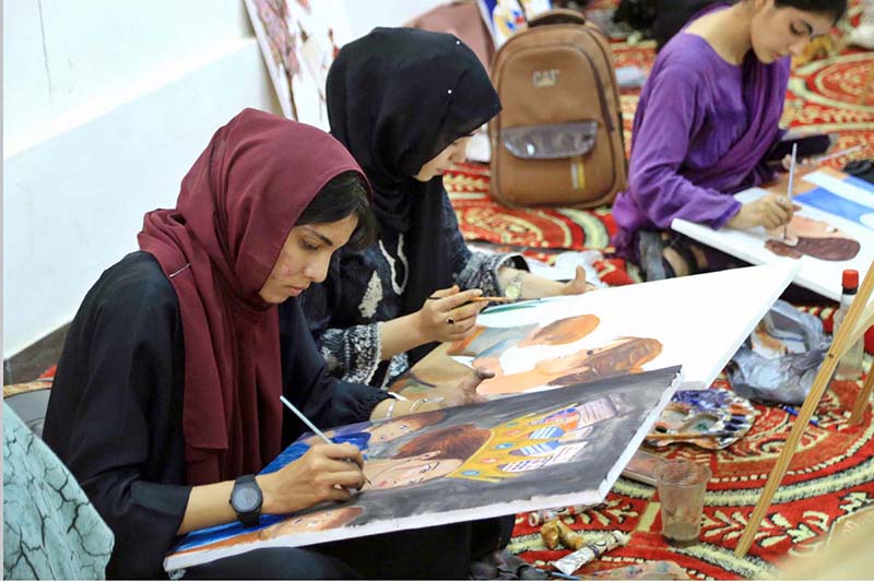 Art students paint portraits during a painting competition organized by the Information and Culture Department Punjab at the Multan Arts Council