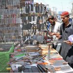 People are busy purchasing knives from a roadside setup to be used for slaughtering sacrificial animals during Eidul Azha