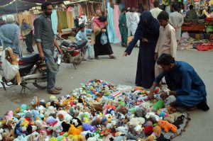 A family browsing cotton toys for purchase at a local bazaar.