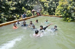 Youngsters enjoy bathing under a running tube-well to get relief from the scorching heat at Khesana Mori village.