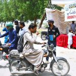 Workers of the Cantonment Board Hyderabad serve chilled drinking water to citizens at a heatstroke relief camp set up on Alamgir Road amid scorching weather conditions
