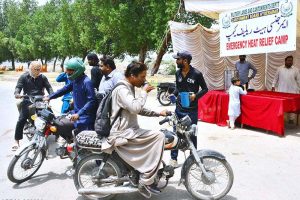 Workers of the Cantonment Board Hyderabad serve chilled drinking water to citizens at a heatstroke relief camp set up on Alamgir Road amid scorching weather conditions