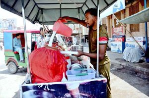 A street vendor prepares and sells traditional buttermilk (lassi) to provide relief to customers amid extreme heat at Dera Adda Chowk.