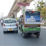 An auto-rickshaw driver uses his foot to propel his vehicle forward after running low on fuel while travelling along Bosan Road
