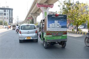 An auto-rickshaw driver uses his foot to propel his vehicle forward after running low on fuel while travelling along Bosan Road