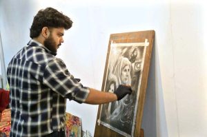 Art students paint portraits during a painting competition organized by the Information and Culture Department Punjab at the Multan Arts Council