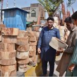 Vendor displaying and selling wooden pieces to be used by butchers to cut meat in pieces during Eidul Azha