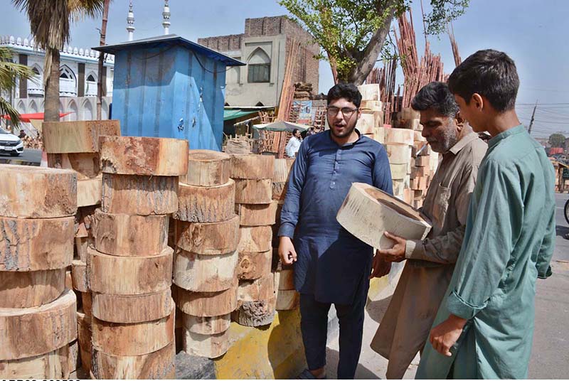 Vendor displaying and selling wooden pieces to be used by butchers to cut meat in pieces during Eidul Azha
