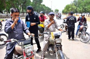 Workers of the Cantonment Board Hyderabad serve chilled drinking water to citizens at a heatstroke relief camp set up on Alamgir Road amid scorching weather conditions
