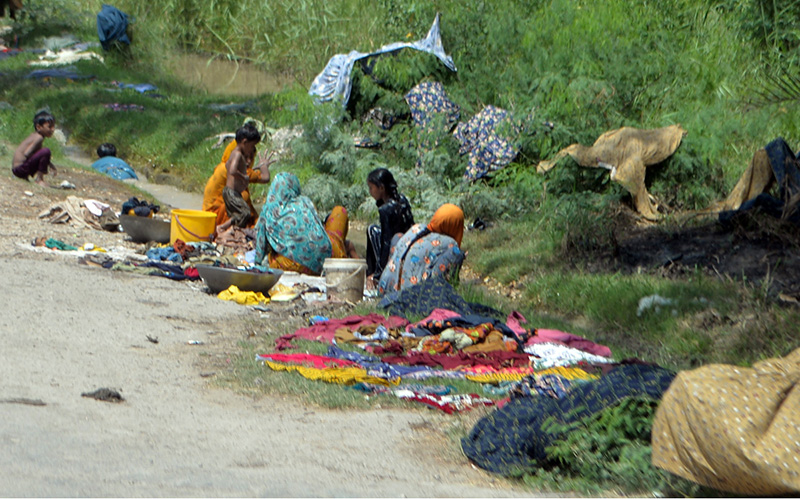 Villager women washing the cloth on roadside at Tando Hyder
