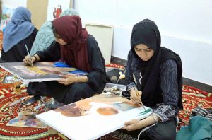 Art students paint portraits during a painting competition organized by the Information and Culture Department Punjab at the Multan Arts Council