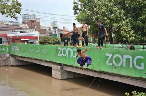 Youngster jumping and bathing in a Canal to get some relief from scorching hot weather due to increasing mercury in the city.