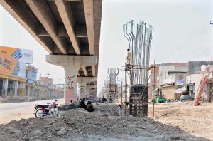Workers busy in the construction of a flyover linking Industrial Estate to old Muzaffargarh road to ease traffic congestion and enhance transportation infrastructure.