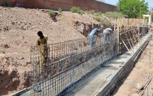 Workers busy fixing iron rods at an under-construction drainage project site during development work in the city.