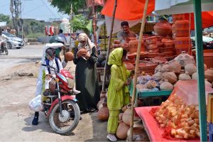 A family purchasing clay pot from a roadside setup near Istaqlalabad colony.