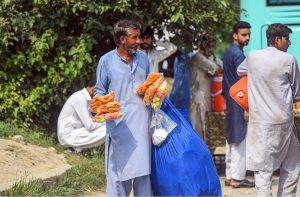 Vendor selling coconut at bus stop in the Federal Capital to earn his livelihood