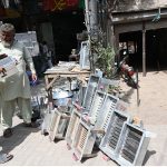 a vendor is selling charcoal grills (angethe) at Muslim Bazaar
