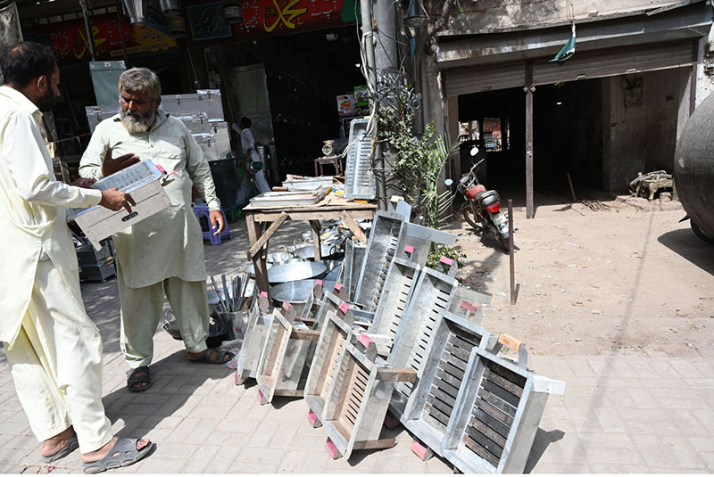 a vendor is selling charcoal grills (angethe) at Muslim Bazaar