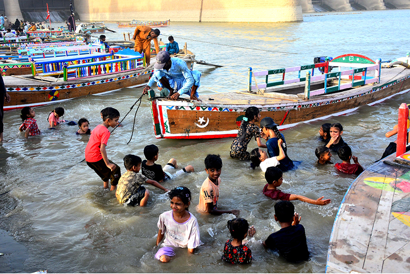 Children bathing in the Indus River to get relief from the heat during the third day of Eid-ul-Azha