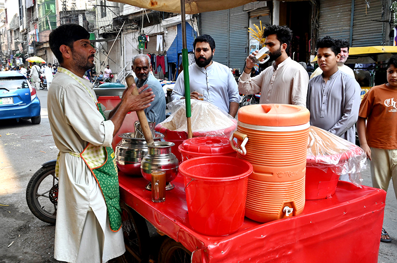 A street vendor sells Sattu, a traditional summer drink mix, from a handcart