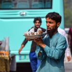 Vendor selling coconut at bus stop in the Federal Capital to earn his livelihood