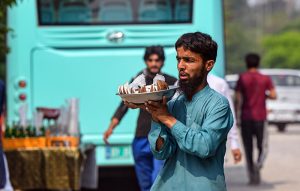 Vendor selling coconut at bus stop in the Federal Capital to earn his livelihood