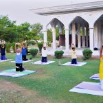 Citizens perform yoga exercises during an early morning fitness session at a public park in the city