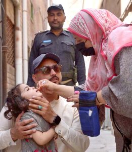 A health worker administers a polio vaccine to a child during a door-to-door vaccination campaign at Faqirabad area.