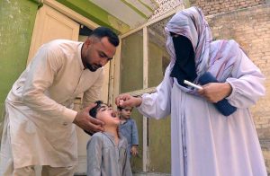 A health worker administers a polio vaccine to a child during a door-to-door vaccination campaign at Faqirabad area.
