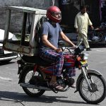 A motorcyclist takes an air cooler on his bike to a mechanic in the city for repair as the heat continues to rise day by day