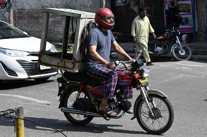 A motorcyclist takes an air cooler on his bike to a mechanic in the city for repair as the heat continues to rise day by day
