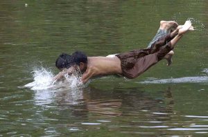 Youngsters diving in the Rawal Lake spillway stream water to beat the heat in a hot day experiencing in the federal capital.