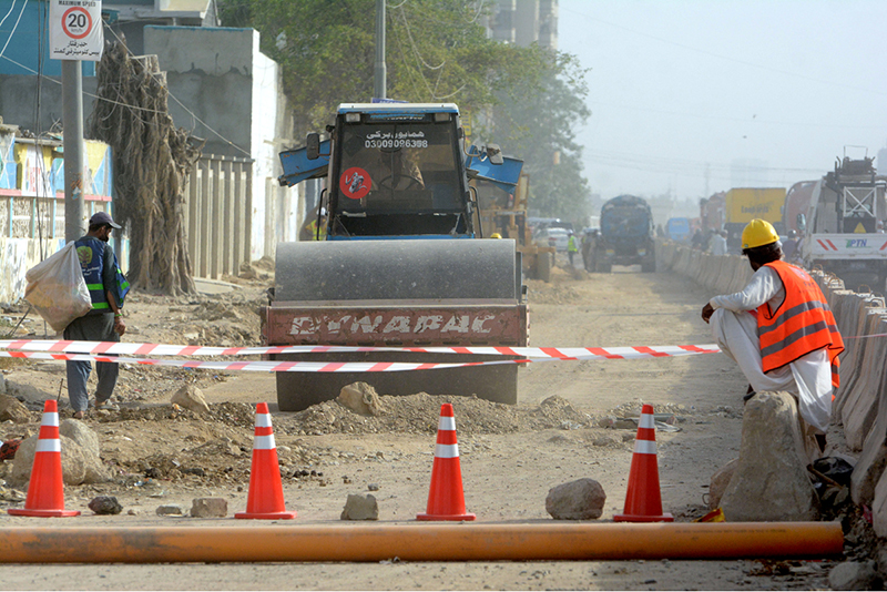 Heavy machinery is being used to extend the road as construction work continues in the Jail Chowrangi area under a city development project