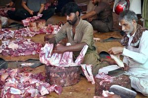 Butchers are busy preparing meat after slaughtering sacrificial animals at Jamia Naeemiyah on the first day of Eidul Azha