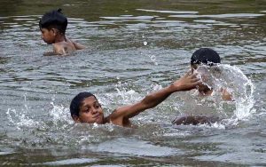 Youngsters diving in the Rawal Lake spillway stream water to beat the heat in a hot day experiencing in the federal capital.