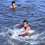 Children are seen taking a bath in the Arabian Sea as the city’s temperature soars amid hot weather conditions