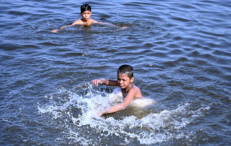 Children are seen taking a bath in the Arabian Sea as the city’s temperature soars amid hot weather conditions