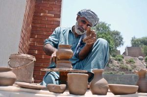 An artist making clay pots during inauguration of museum on the occasion of World Museum Day.