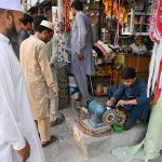 A blacksmith is busy sharpening knives and axes to be used for slaughtering sacrificial animals during Eid ul Azha