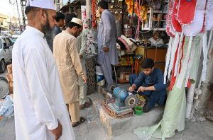 A blacksmith is busy sharpening knives and axes to be used for slaughtering sacrificial animals during Eid ul Azha