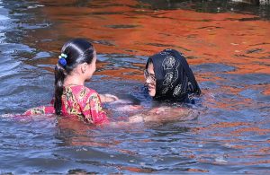 Children are seen taking a bath in the Arabian Sea as the city’s temperature soars amid hot weather conditions