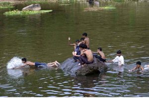 Youngsters diving in the Rawal Lake spillway stream water to beat the heat in a hot day experiencing in the federal capital.