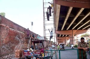 Workers are busy renovating a wall along the railway station track, enhancing its beauty.