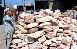 A vendor displays solid rocks of salt at his roadside setup.